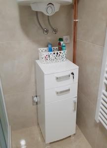 un armario blanco con una cesta encima en el baño en Apartman KIWI in a quite central area, en Banja Luka 25 fotos más