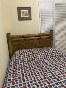a bed in a bedroom with a wooden head board at Beach Vue Barbados in Bridgetown