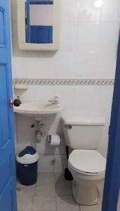a bathroom with a white toilet and a sink at Finca del Rio Palomino in Palomino