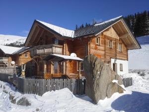 a log cabin in the snow with a fence at Almrauschhütte Markus in Lachtal