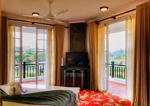 a living room with a couch and a balcony with sliding glass doors at The Blackpool Resort & Spa in Nuwara Eliya