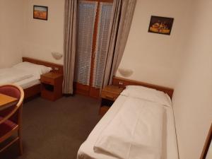 a small room with two beds and a window at Pension Marianne in Maranza