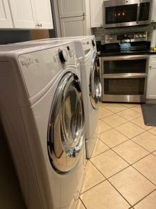 a washing machine in a kitchen with a microwave at Our Home, Your Home in Black Mountain