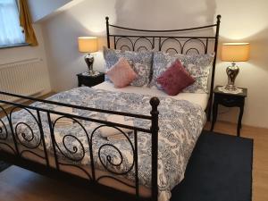 um quarto com uma cama preta com almofadas e 2 candeeiros em Karmelita Boutique Apartman em Sopron