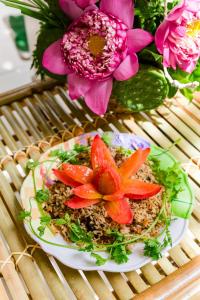 um prato de comida numa mesa com flores em Buddha Homestay em Can Tho