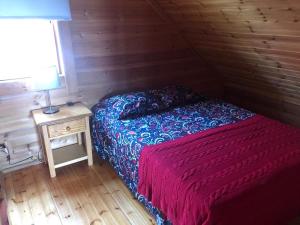 1 dormitorio con 1 cama y 1 mesa con lámpara en Chalé 6 en Penhas da Saúde