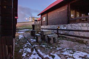 a group of stone benches in front of a building at Chalé 6 in Penhas da Saúde