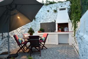 a patio with a table and chairs and an umbrella at Salty Stories in Ponta Delgada