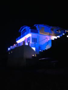 a building lit up in blue at night at Aqua De Vida in Bhowāli