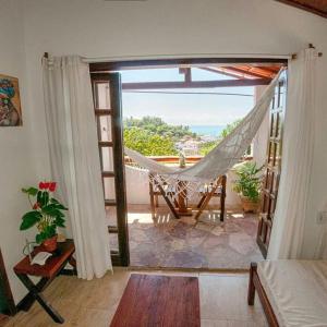 Una habitación con hamaca y vista al mar. en Apartamentos Quintal, en Morro de São Paulo