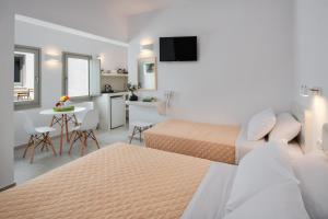 a hotel room with two beds and a kitchen at Olive Tree Suites in Fira