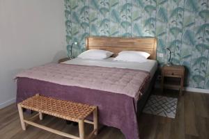 a bedroom with a large bed with a wooden headboard at La Palmeraie - Appartement classé 4 étoiles - Hyper centre ville in Quimper