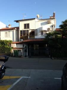 a white house with a fence in front of a street at Apartments Oliva in Poreč