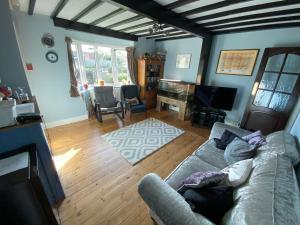 a living room with a couch and a television at Waterside Guesthouse in Dymchurch