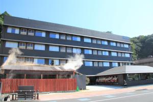 um edifício negro com fumo a sair dele em Iseya, Seaview Private Onsen Bath em Unzen
