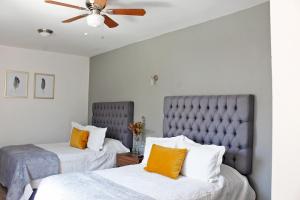 a bedroom with two beds and a ceiling fan at Suites ciento 37 in León