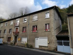a building with white doors and windows on a street at La Prunelle 1 in Ferrières-Saint-Mary
