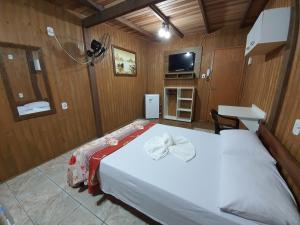 a bedroom with a bed with a bow on it at Residencial Rei Thomas in Capão da Canoa