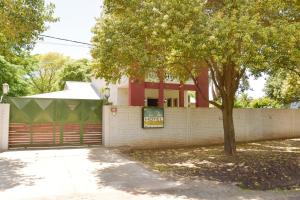 una cerca con un árbol delante de una casa en Casa Calma Hotel en Santo Tomé