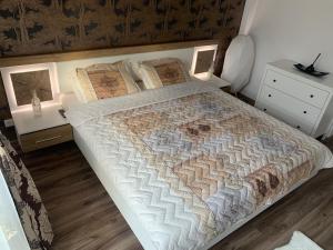 um quarto com uma cama com uma colcha em Vintage Home em Sinaia