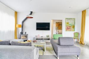 a living room with a couch and chairs and a tv at Jewel Home in Sant Pere de Ribes