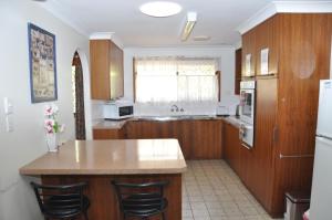 a kitchen with wooden cabinets and a counter top at Rangehouse in Toowoomba