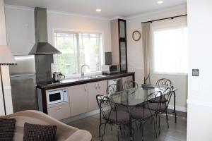 a kitchen with a glass table and chairs in a kitchen at Lodge Bordeaux in Whangarei