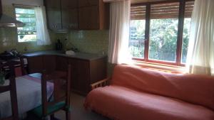 a living room with a couch and a kitchen with windows at Nomeolvides in Tandil