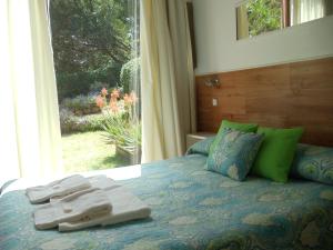 een bed met handdoeken en een raam bij Dandy Suites in Mar de las Pampas