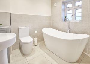 y baño con bañera, aseo y lavamanos. en Host & Stay - Hoggarths Retreat, en Whitby