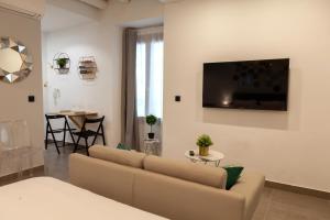 uma sala de estar com um sofá e uma televisão na parede em VITORES BOUTIQUE APARTAMENTOS Rincón del Regidor em Úbeda