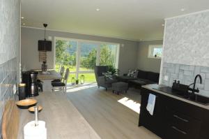 eine Küche und ein Wohnzimmer mit einem Tisch und einem Sofa in der Unterkunft Romsdalseggen Lodge in Isfjorden