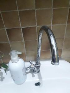 a sink with a soap dispenser next to a faucet at Art Home in Prijedor