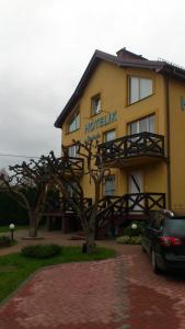 um hotel com uma árvore em frente em Hotelik u Sąsiada em Olsztyn