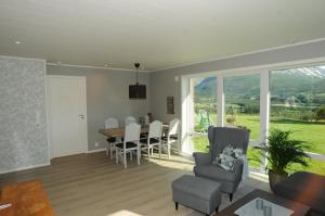 a living room and dining room with a table and chairs at Romsdalseggen Lodge in Isfjorden