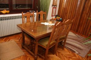 een houten tafel en stoelen in de woonkamer bij Art Home in Prijedor