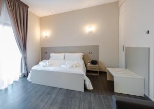 a bedroom with a large white bed and a table at Aparthotel ParKHo in Potenza