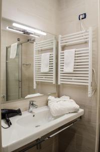 a bathroom with a sink and a mirror and towels at Aparthotel ParKHo in Potenza