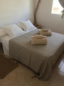 duas toalhas sentadas em cima de uma cama em Bilocale vista mare Es Pujols em Es Pujols