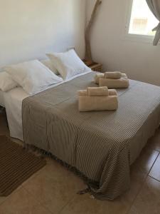 two towels sitting on top of a bed at Bilocale vista mare Es Pujols in Es Pujols