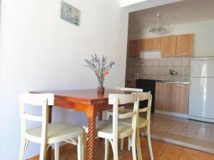 Il comprend une cuisine et une salle à manger avec une table et des chaises en bois. dans l'établissement Apartments Amfora, à Gdinj