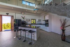 an open kitchen with a counter and stools at The Dreaming View Villa in Haad Yao
