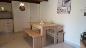a small kitchen with a wooden table and benches at House Ivan in Postira