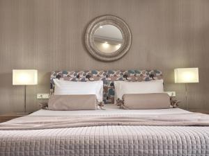 1 dormitorio con 1 cama grande y espejo en la pared en Koukounaria Hotel & Suites, en Alykes