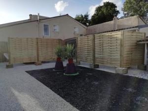 a fence in front of a house with potted plants at Naphéo in Tonnay-Charente