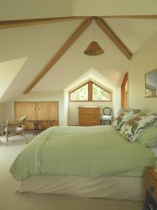 Mahinepua的住宿－懷瓦里埃海岸農場旅館，一间卧室配有一张绿色的床和一张桌子