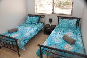 1 dormitorio con 2 camas y ventana en Ridgehouse en Toowoomba