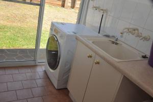 a washing machine in a kitchen next to a sink at Ridgehouse in Toowoomba