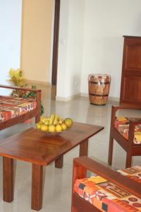 a room with a table with a bowl of fruit on it at Résidence Séjourné in Les Anses-dʼArlets