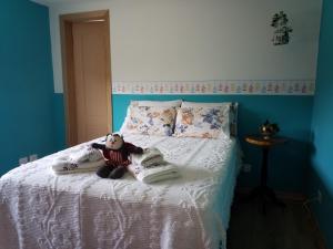 a bed with a teddy bear sitting on it at Flor de Canela in São Roque +5 photos